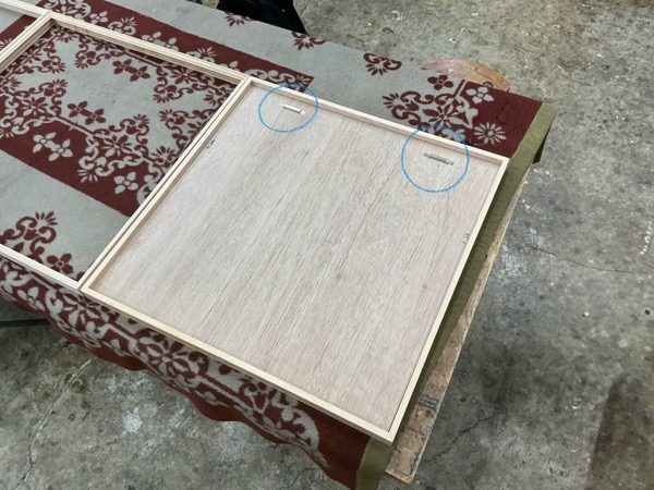 額縁の裏面に取り付けたティースハンガー（丸印の位置）